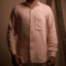 Men's pastel pink linen shirt with a front pocket, casual style.