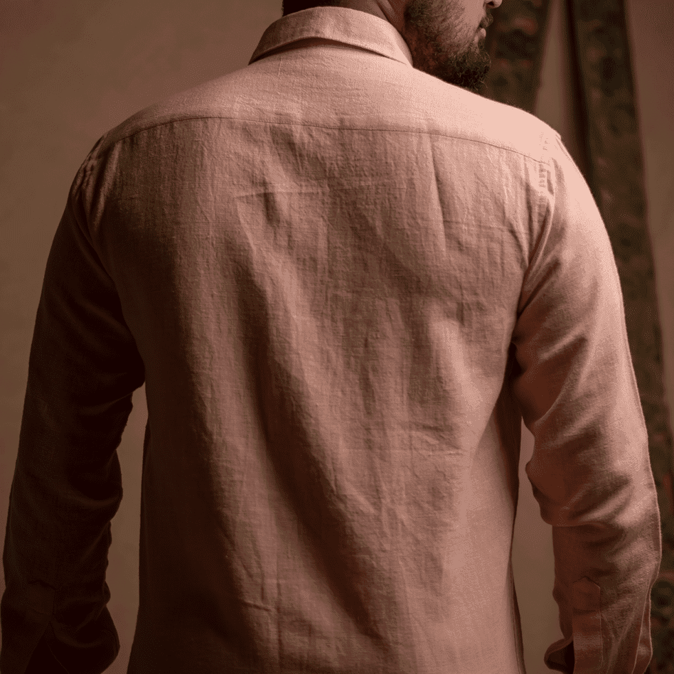 Close-up of a man wearing a beige linen shirt, back view, indoors.