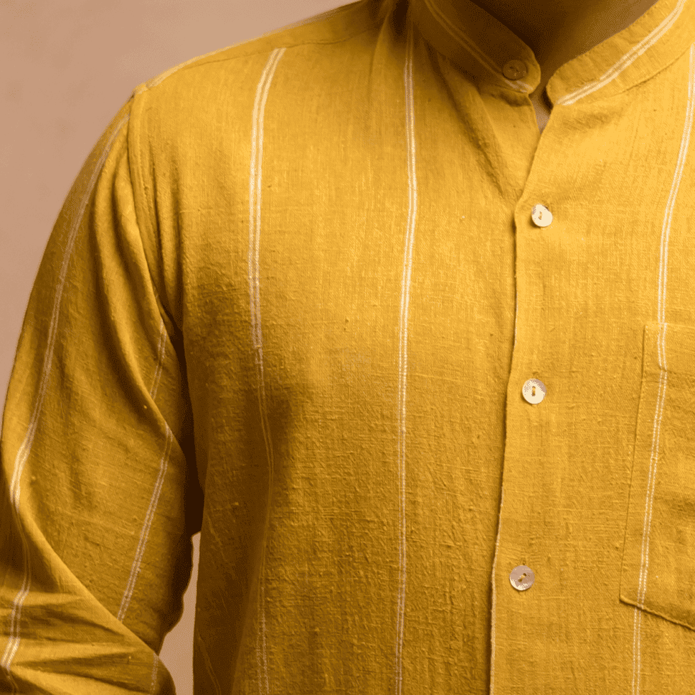 Close-up of a mustard yellow kurta with white vertical stripes.